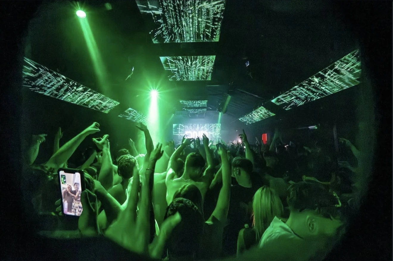 Green stage lighting above a live music crowd
